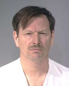 Photograph of Gary Ridgway, notorious serial killer known as the Green River Killer, giving an icy stare in his mugshot during his booking at the King County Sheriff's Office headquarters in Seattle, Washington.