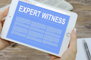 A blue electronic tablet is being held by a woman, with a folded newspaper in the background. The words “Expert Witness” appear at the top of the tablet.
