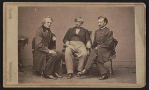 Photograph of the three prosecutors for the Lincoln assassination trial sitting in wooden chairs.