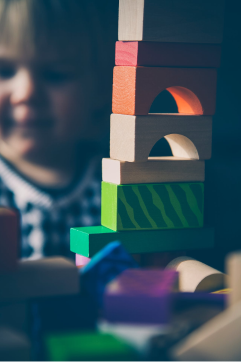 Tower of small stacked blocks with child in background.