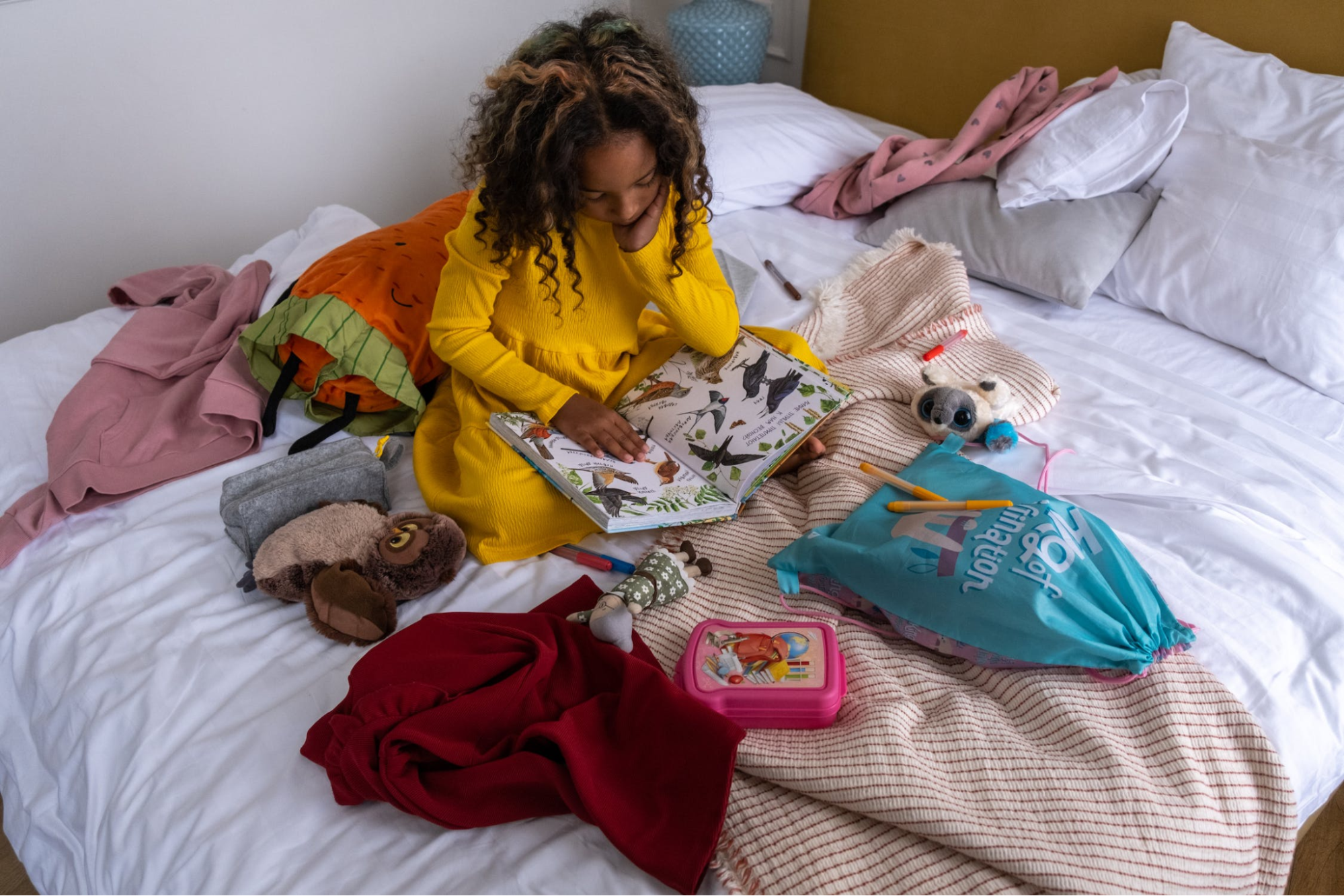 Child reading a book in bed