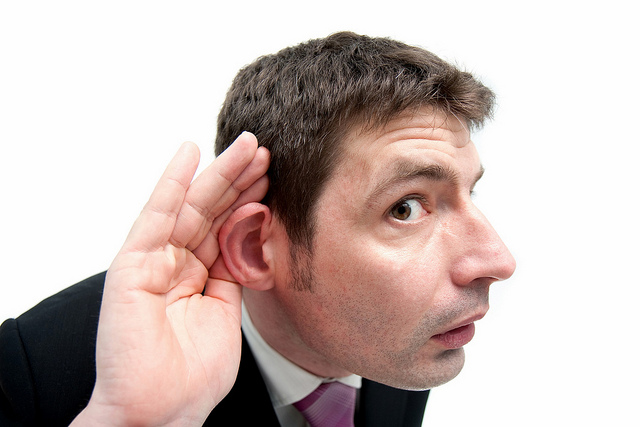 a man cupping his ear