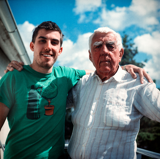 A grandson standing with his arm around his grandpa