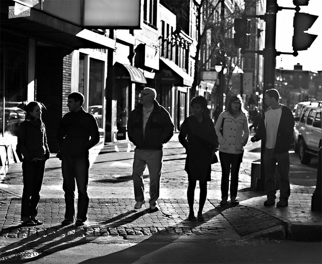 A casual crowd of people crossing the street