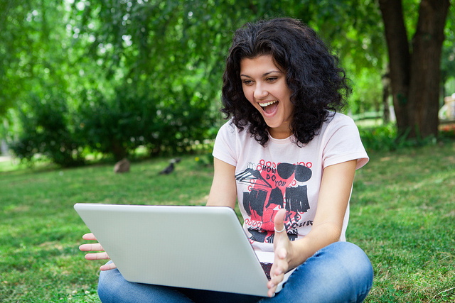 A college student using her laptop in a park