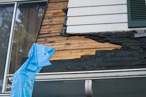 A roof being stripped of shingles to be reshingled