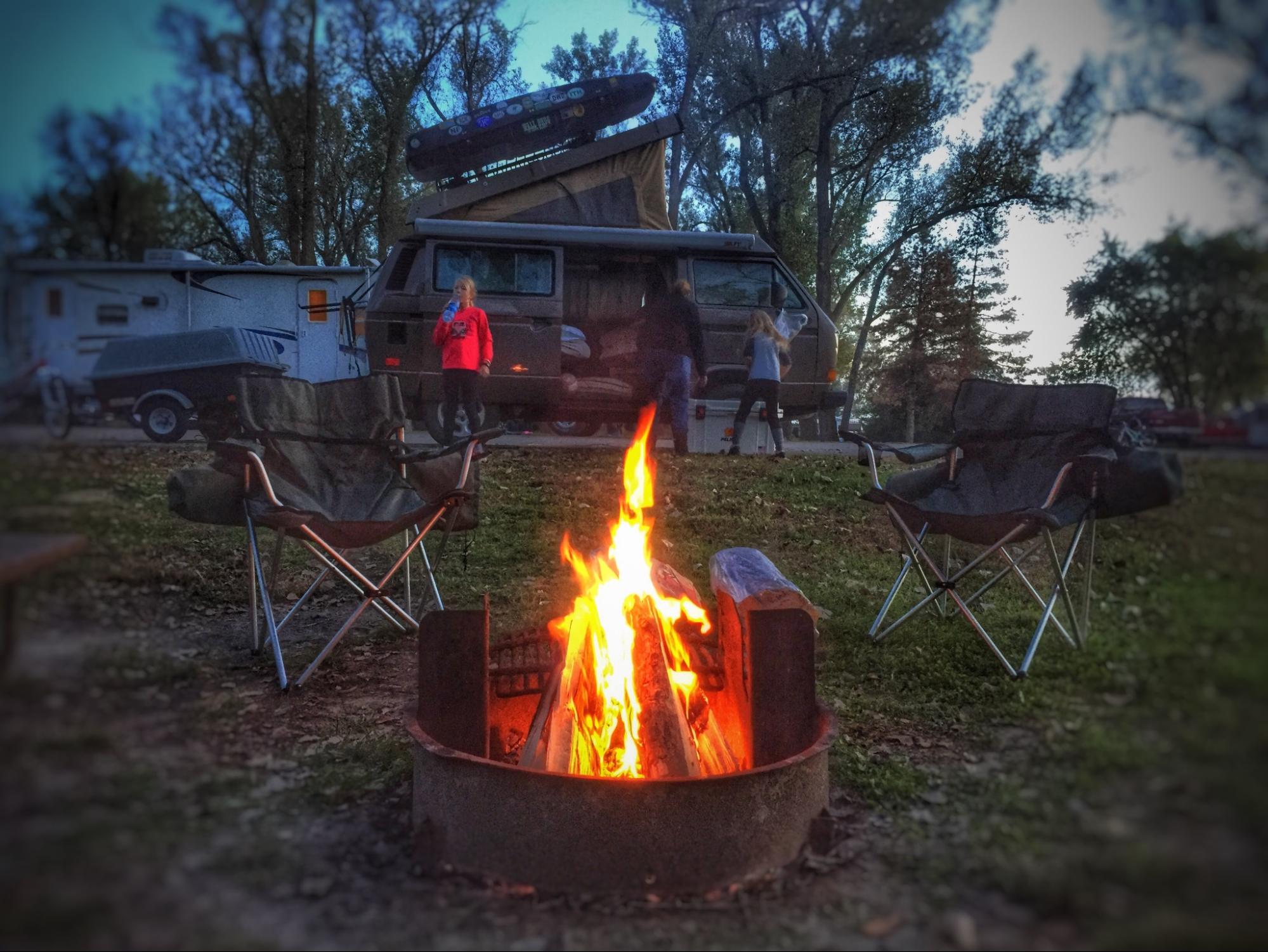 Campers at a fire pit in the Fall.