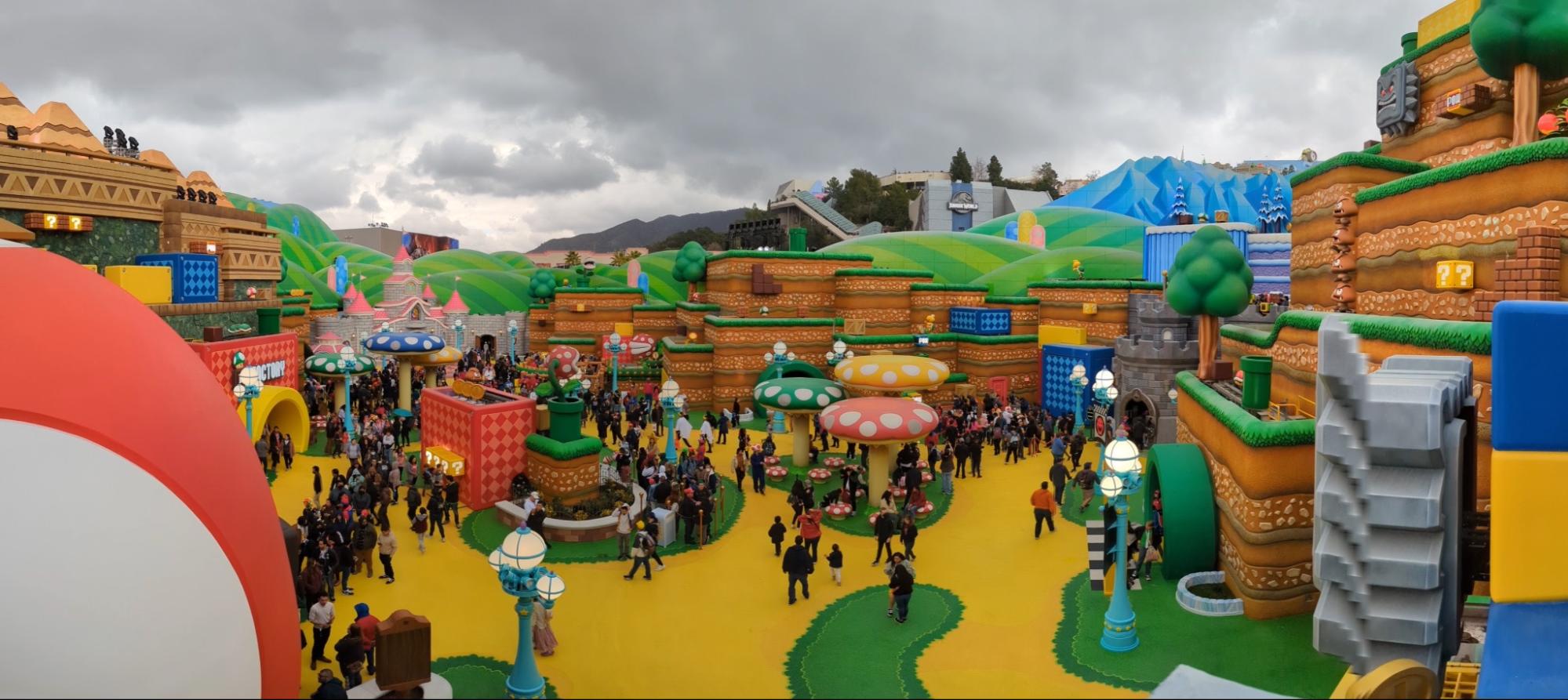 A photograph depicting people walking around an enlarged, 3D recreation of Super Mario World video game.