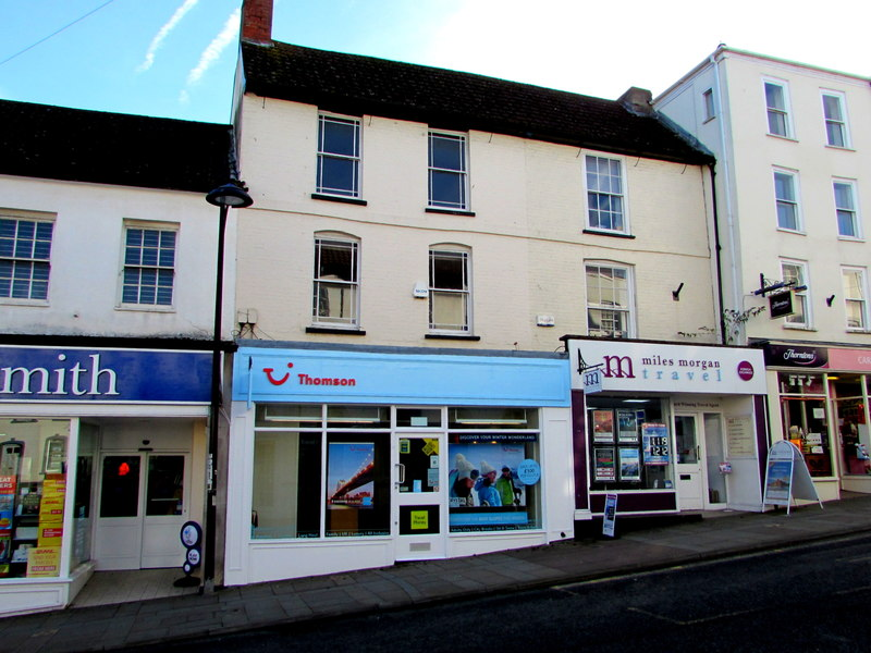 Two travel agent store fronts, Thomson and MIles Morgan Travel, situated adjacent to a street.