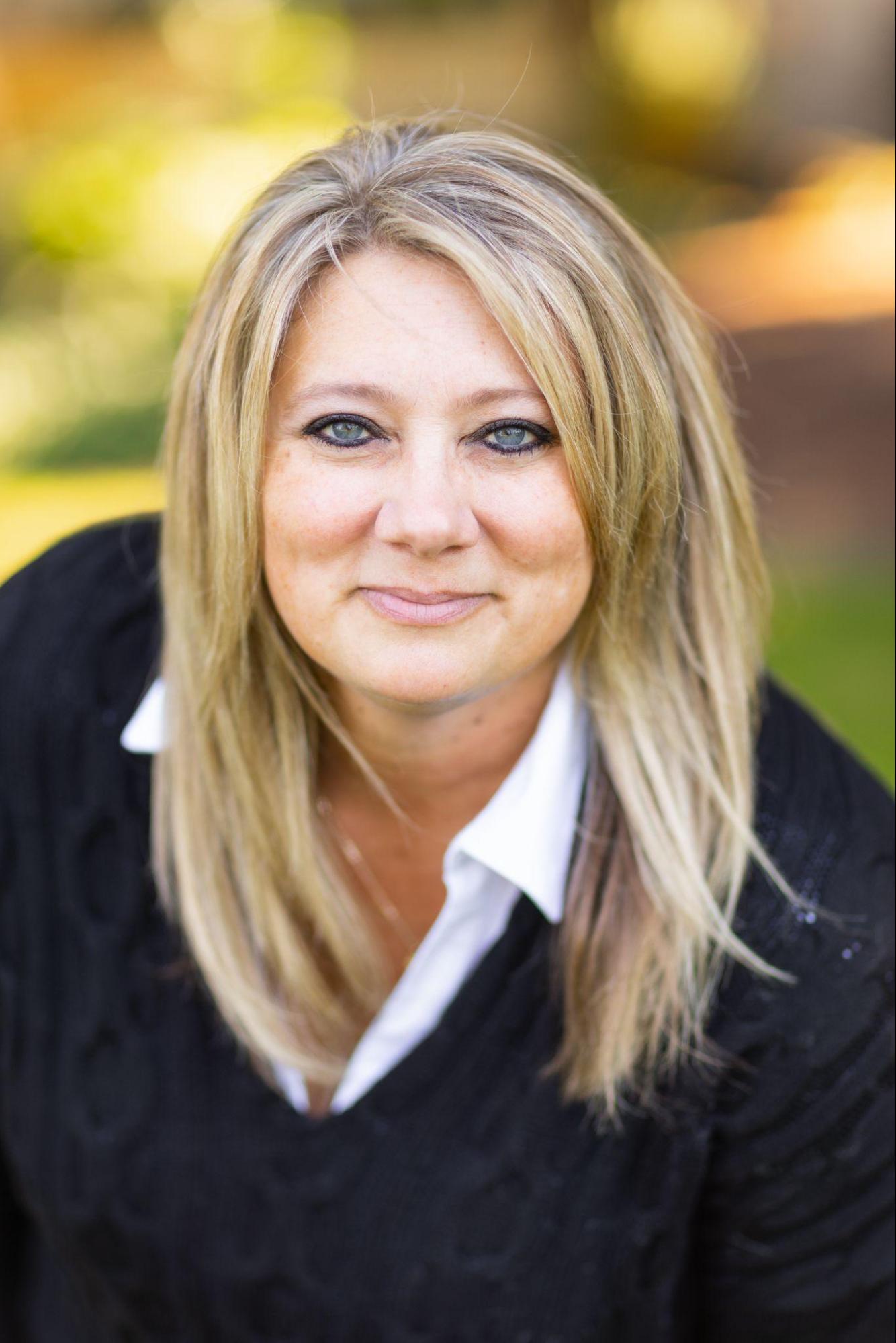 A photograph of Ronda Dean, a woman with blond hair who is smiling directly at the camera.