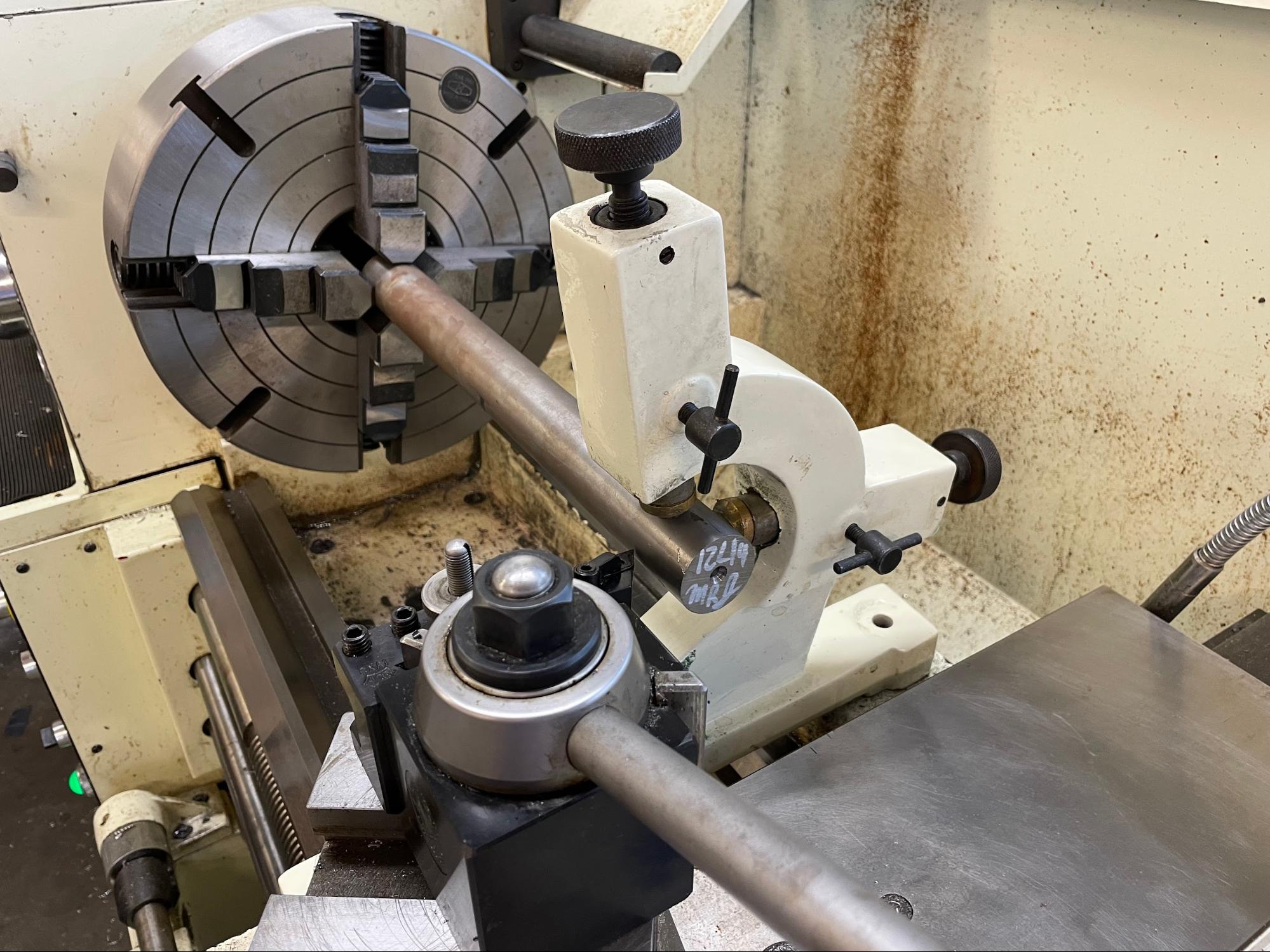 A follower rest in use supporting a long workpiece.