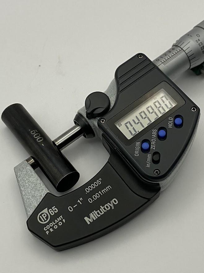 A zero to one inch outside micrometer closed onto a .500 minus inspection pin and the digital display reads 0.49980 inches.