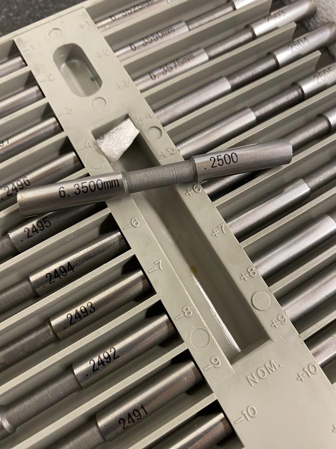 An inspection pin reading .2500 sits on top of an inspection pin set.