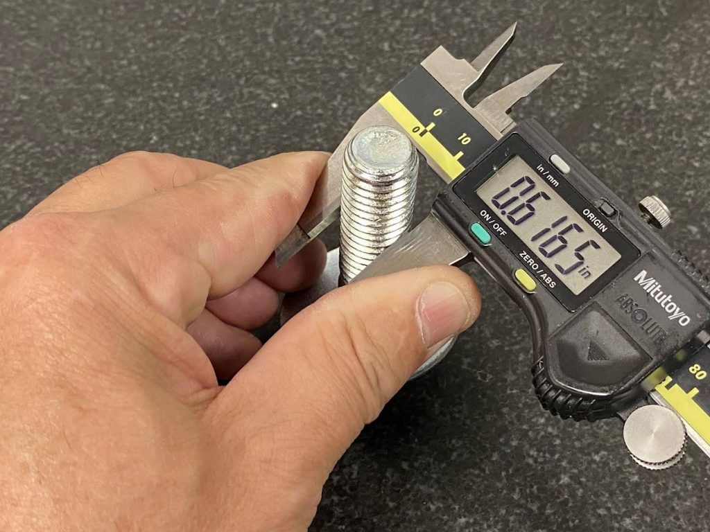 A slide caliper is used for measuring a bolt by closing the jaws by pressing against the jaw surfaces.