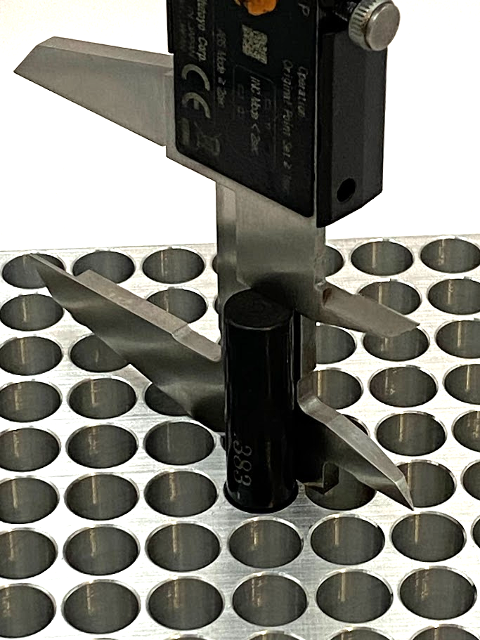 An inspection pin is placed in a hole and contacts a shelf in the hole. A caliper is used to measure the height of the pin extending above the part surface.