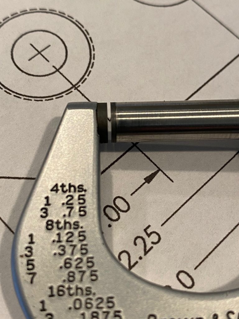 A close up view of the spindle and anvil on a zero to one inch micrometer with a small gap between the two surfaces.