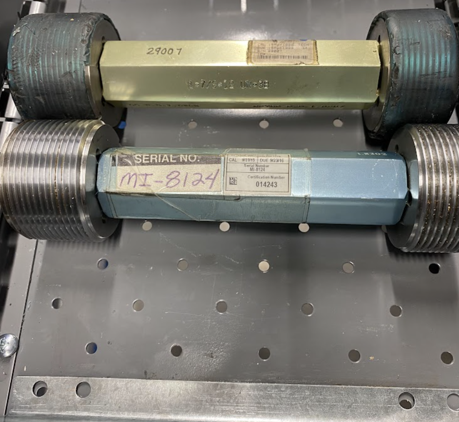 A calibration sticker is applied to a thread plug gage.