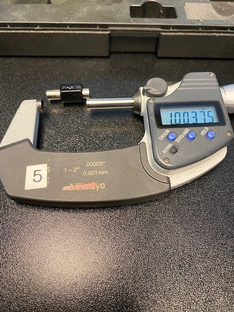 A one to two inch micrometer is displayed with a one inch standard between the open spindle and anvil.