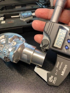 A digital micrometer is closed over a round feature and the display reads 0.99920 inches.