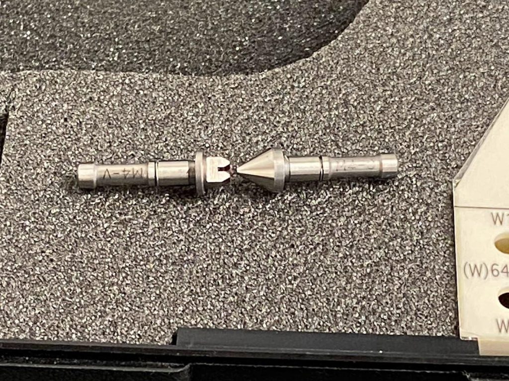 A close up view of the grooved and conical shape of the two thread mic anvils.