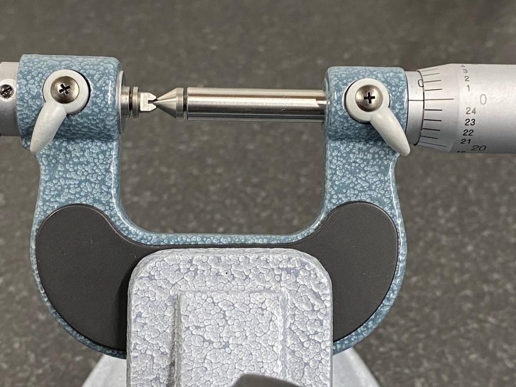 A thread mic with both anvils installed is closed and the scale indicates zero.