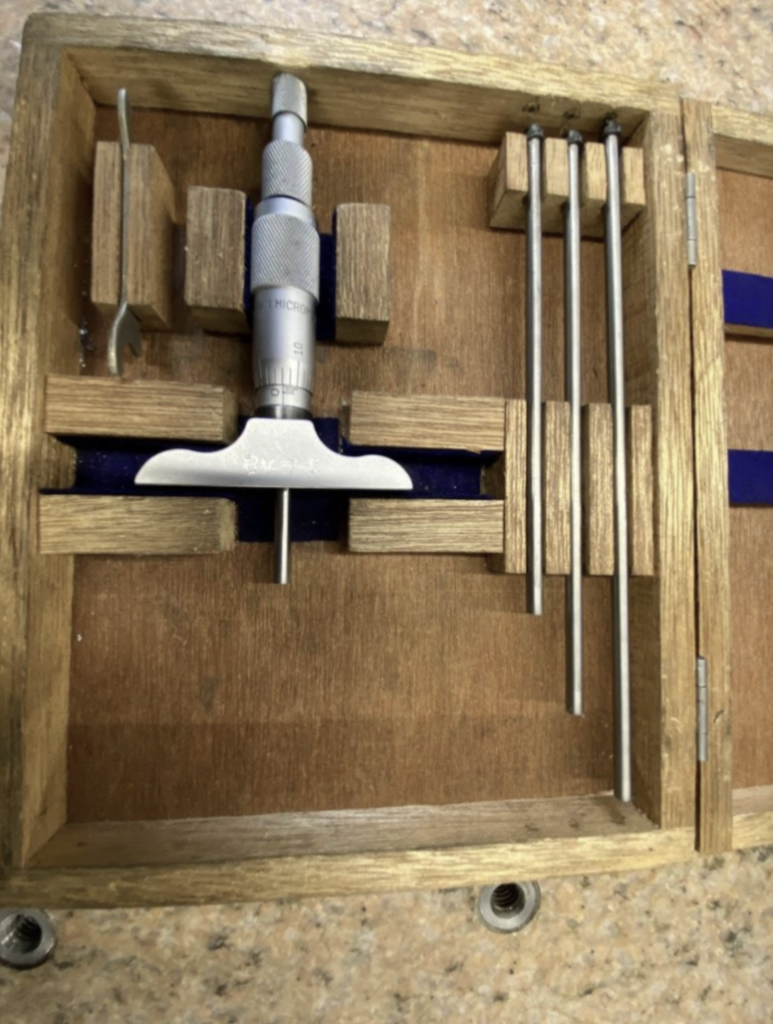 A depth mic set in a box with a mic body and an assortment of different length anvils.