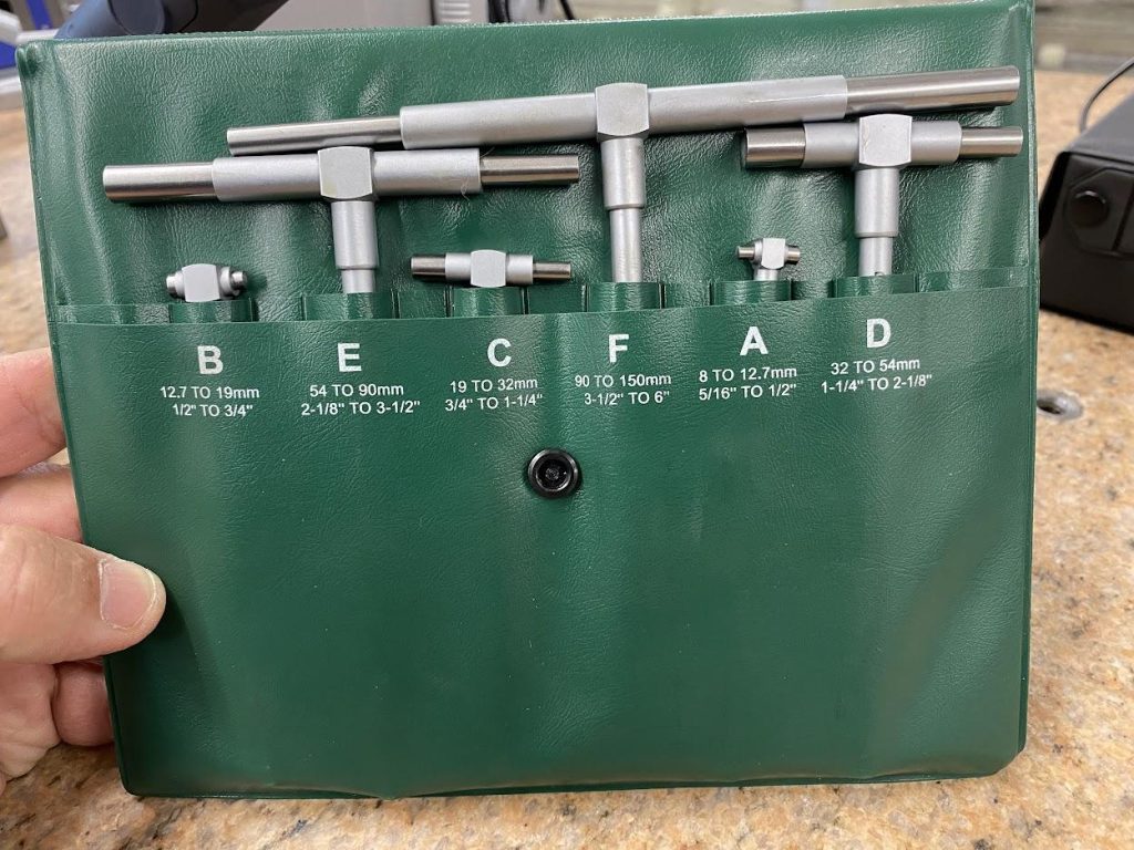 A set of snap gages in a green plastic case.