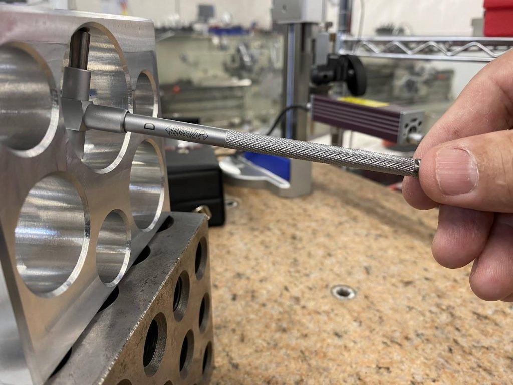 A snap gage in a bore with the handle sloped down.