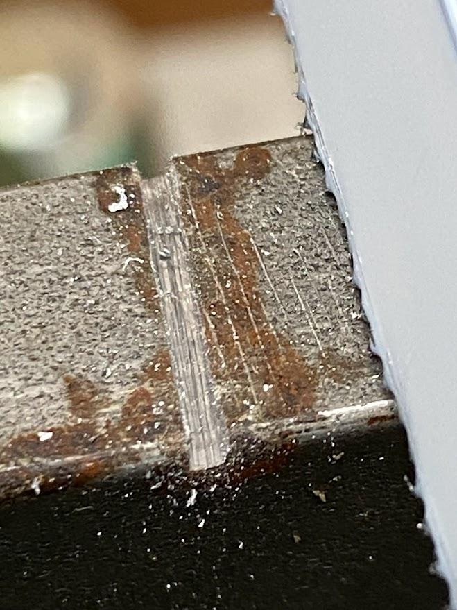 An enlarged photo of a shallow cut in metal.