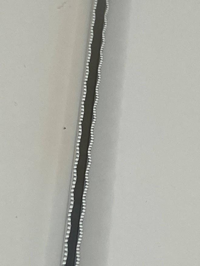 Two hacksaw blades side by side with different wavy tooth set.