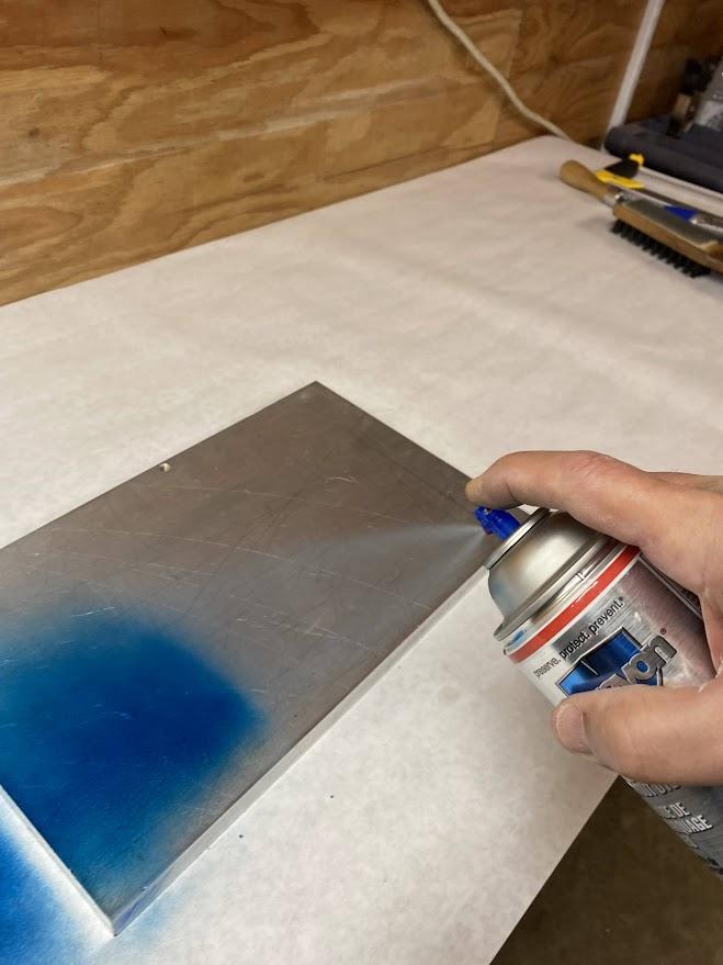 Layout dye is being sprayed on metal.