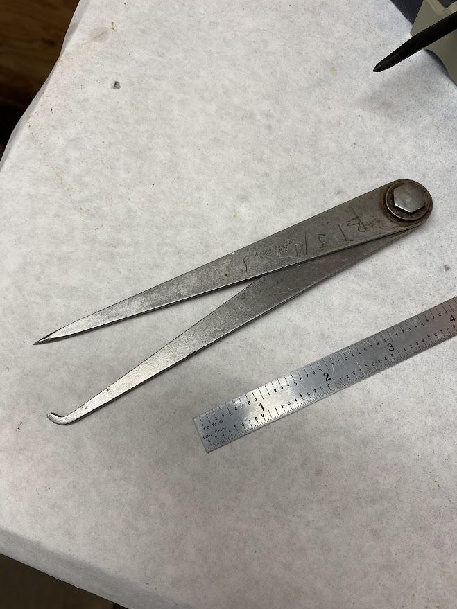 An odd leg caliper has two different legs, one for scribing and the other is hooked to follow the edge of a part.