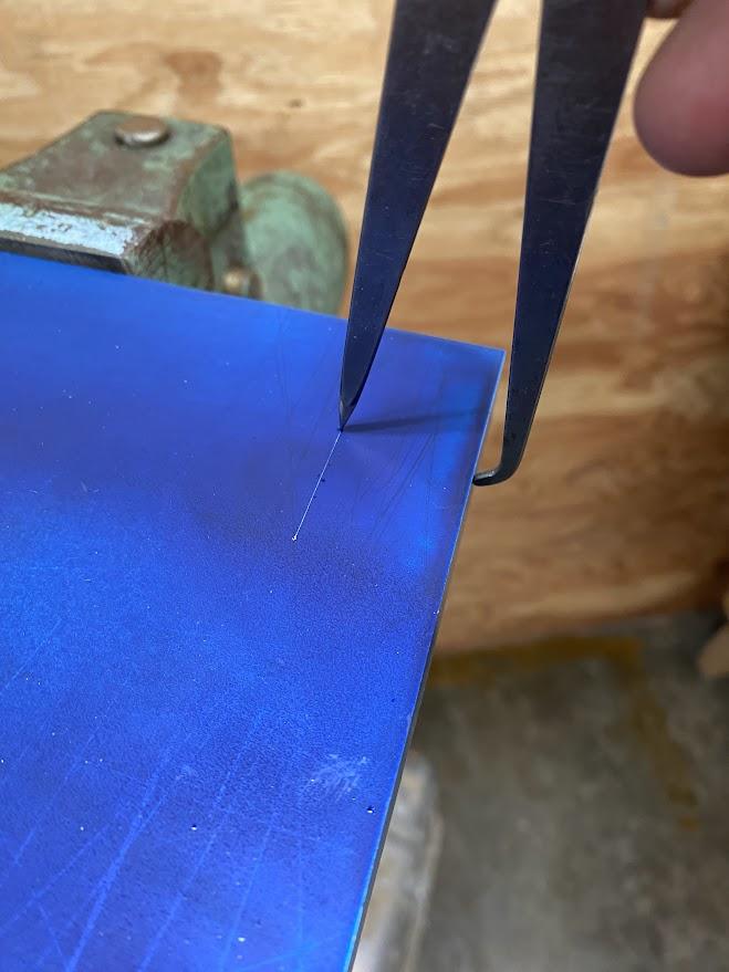 An odd leg caliper is used to scribe a line parallel to the edge of a piece of stock.