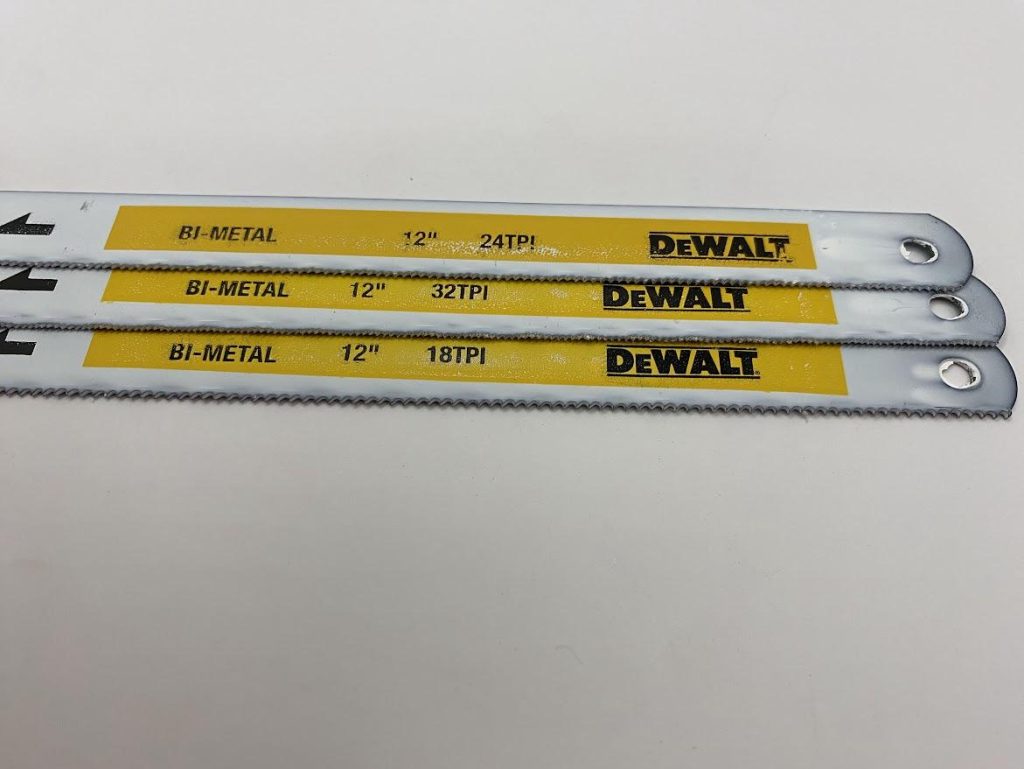Three hacksaw blades are arrayed with different tooth per inch indications visible.
