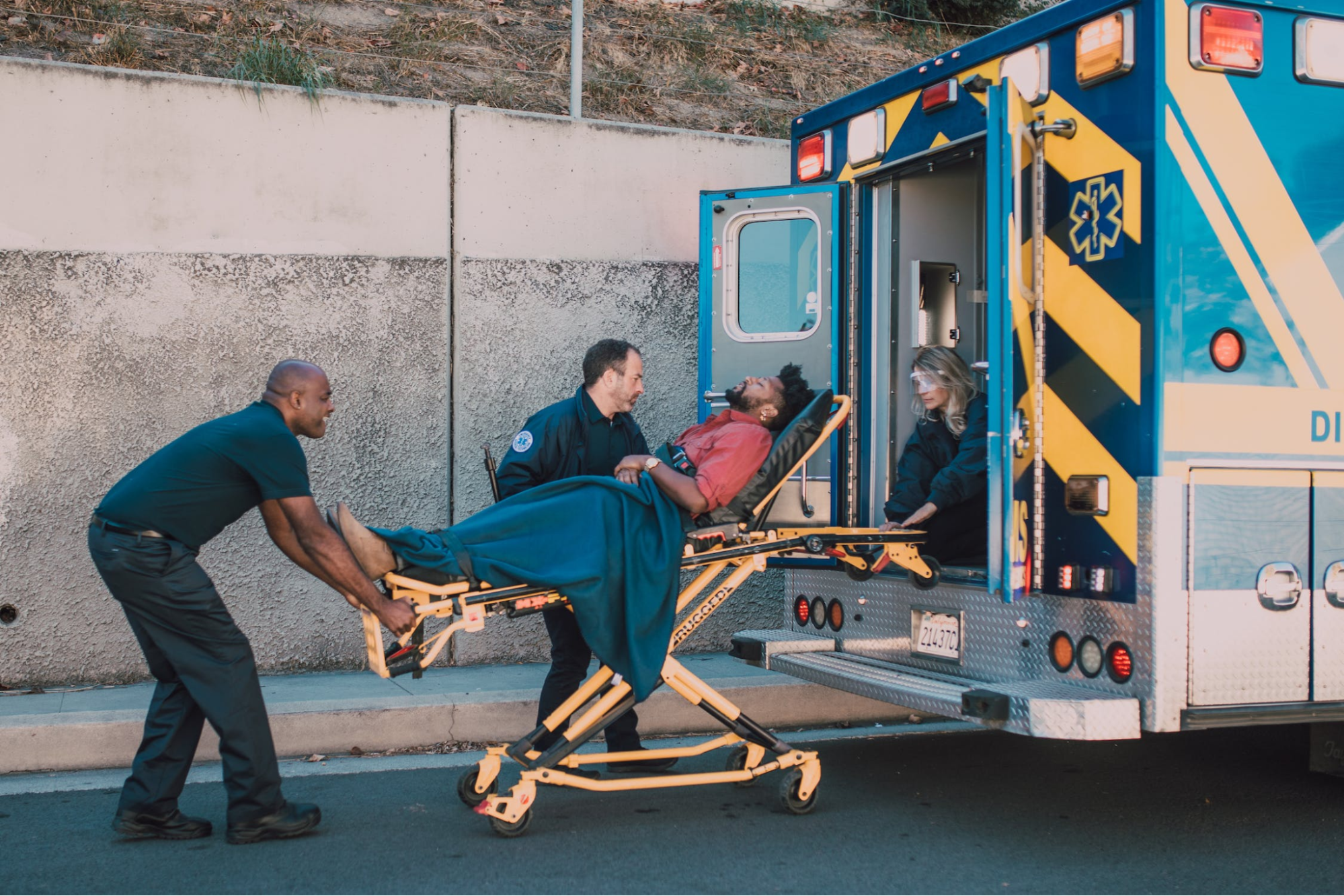 Healthcare personnel loading a patient into an ambulance