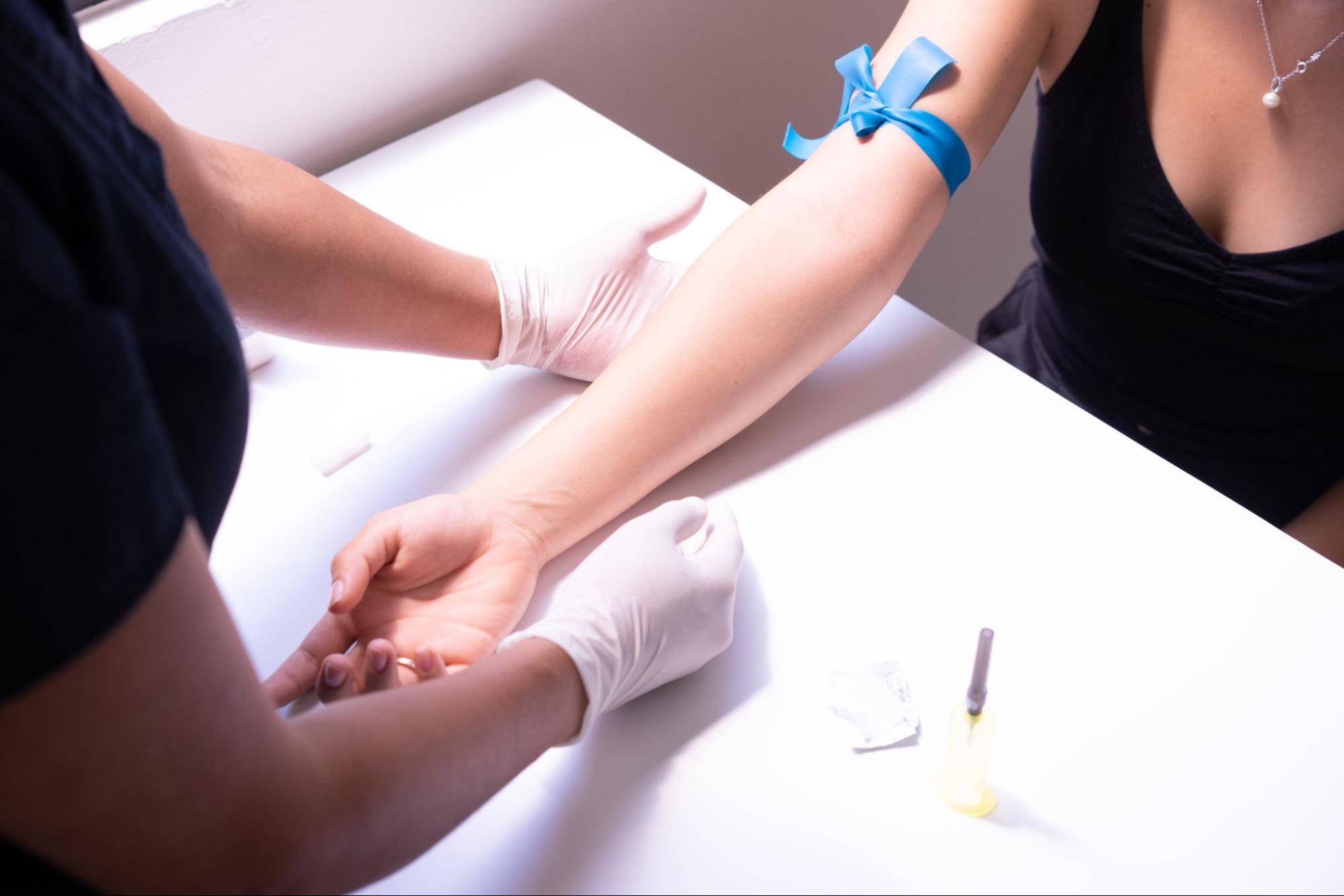 A phlebotomist preparing a patient to have blood drawn.