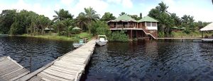 A walking bridge over water leading to a lodge