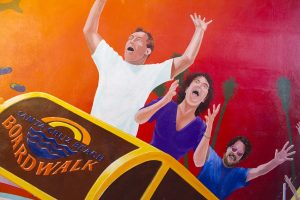 family picture on a roller coaster with hands in the air