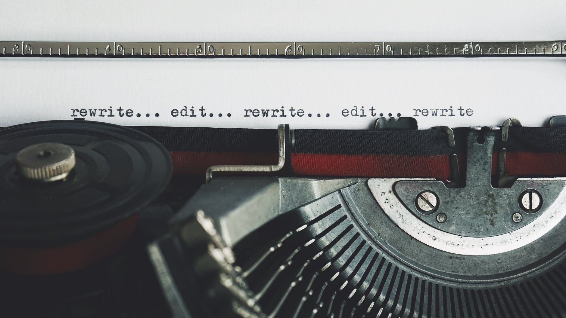 An old fashioned type writer with the typed words, "rewrite... edit... rewrite... edit... rewrite"