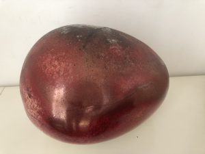 A smooth ovular stone, in deep red and a black crack on the top.