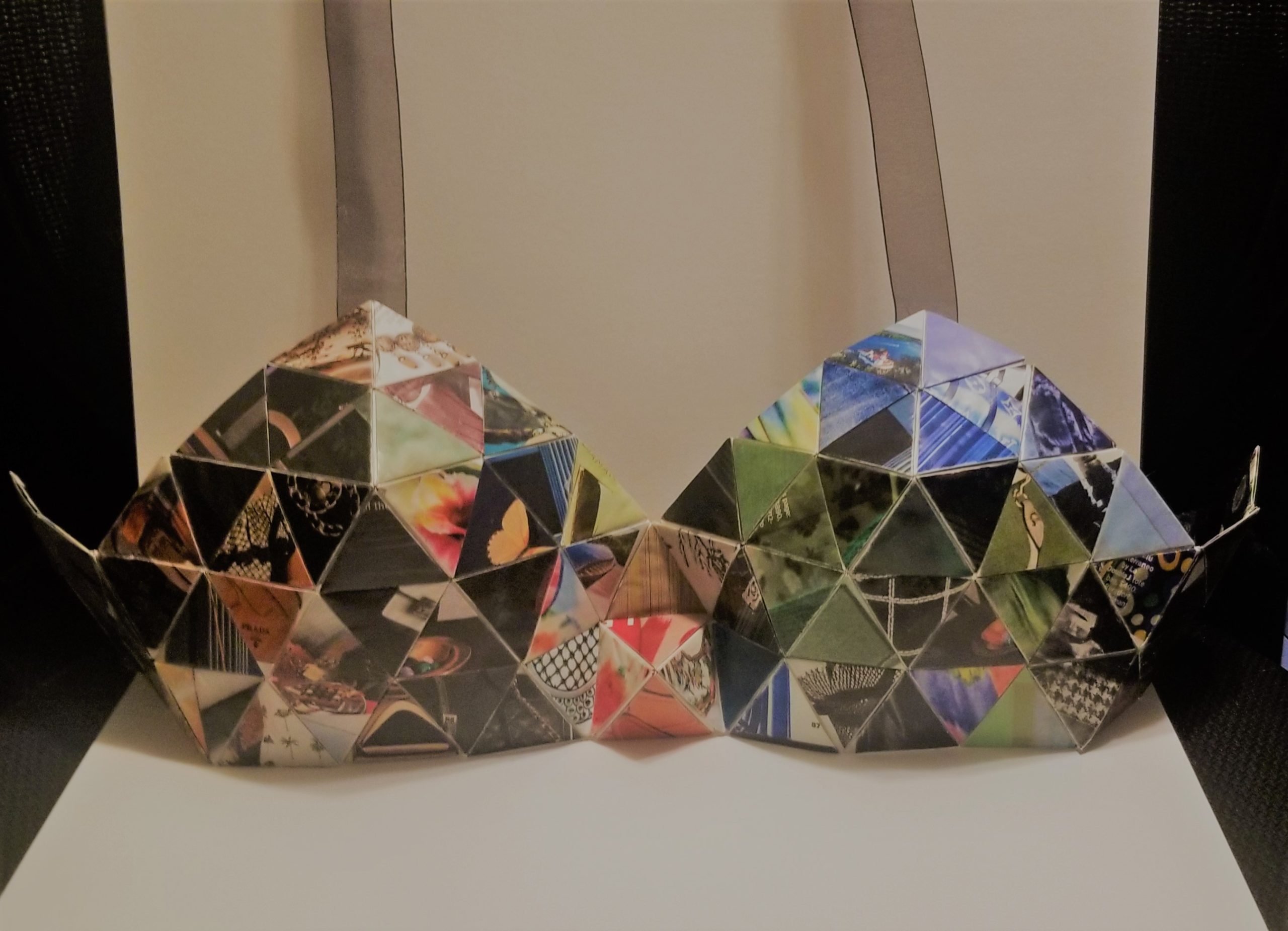 A pointed bra fashioned out of multicolor paper triangles. There are ribbon straps ascending from the top.