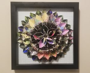 Multicolor paper folded into many petals. They are layered on top of one another, each tier showing a different color scheme.