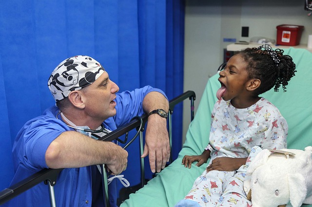 A white doctor being goofy with a black girl patient