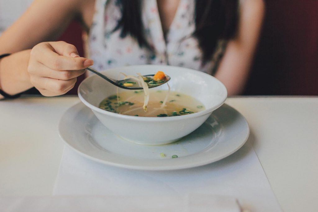 Woman eating soup at a table