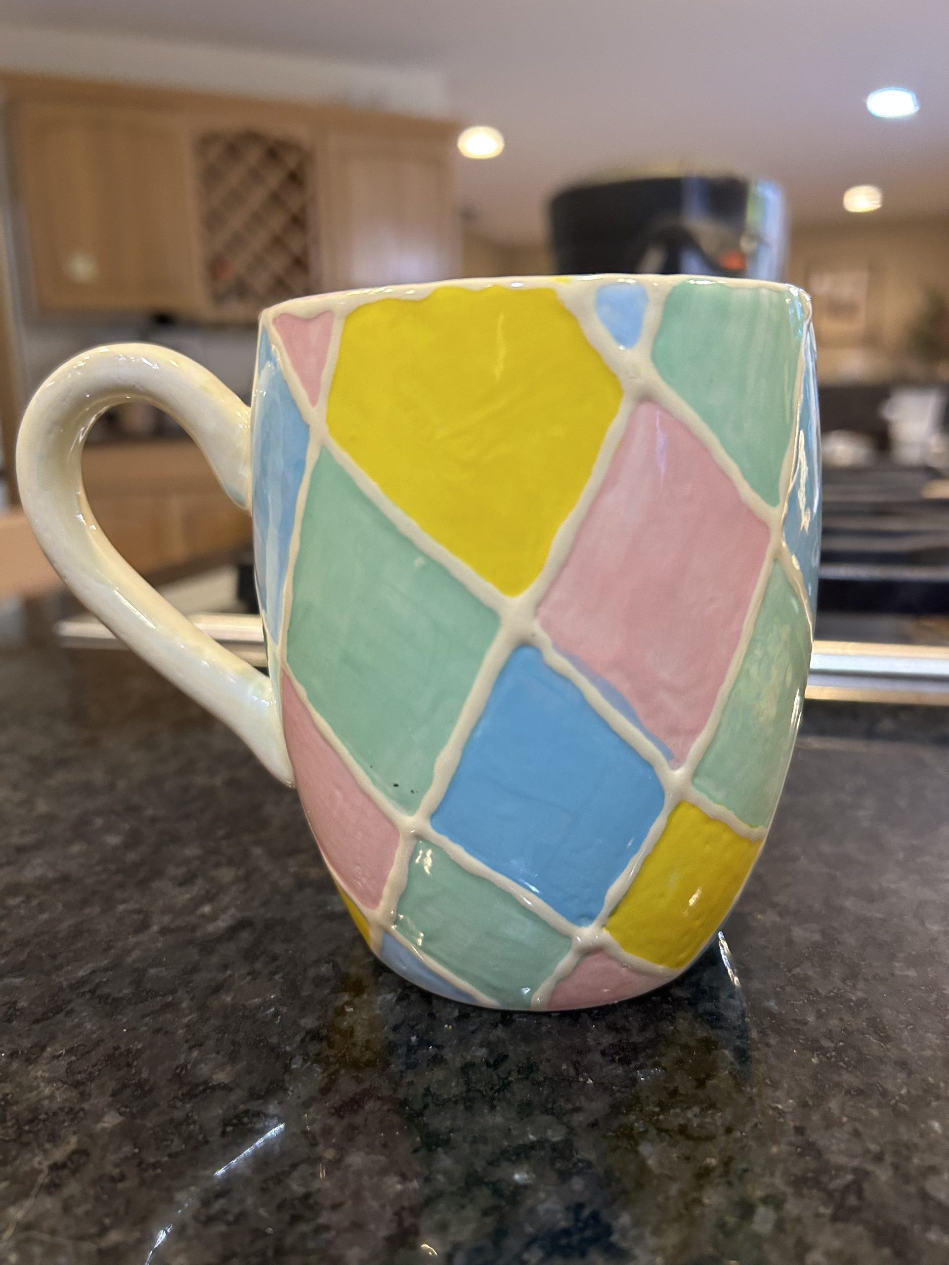 Ceramic mug with geometric pastel shapes and a lemon and lime wedge - side of mug