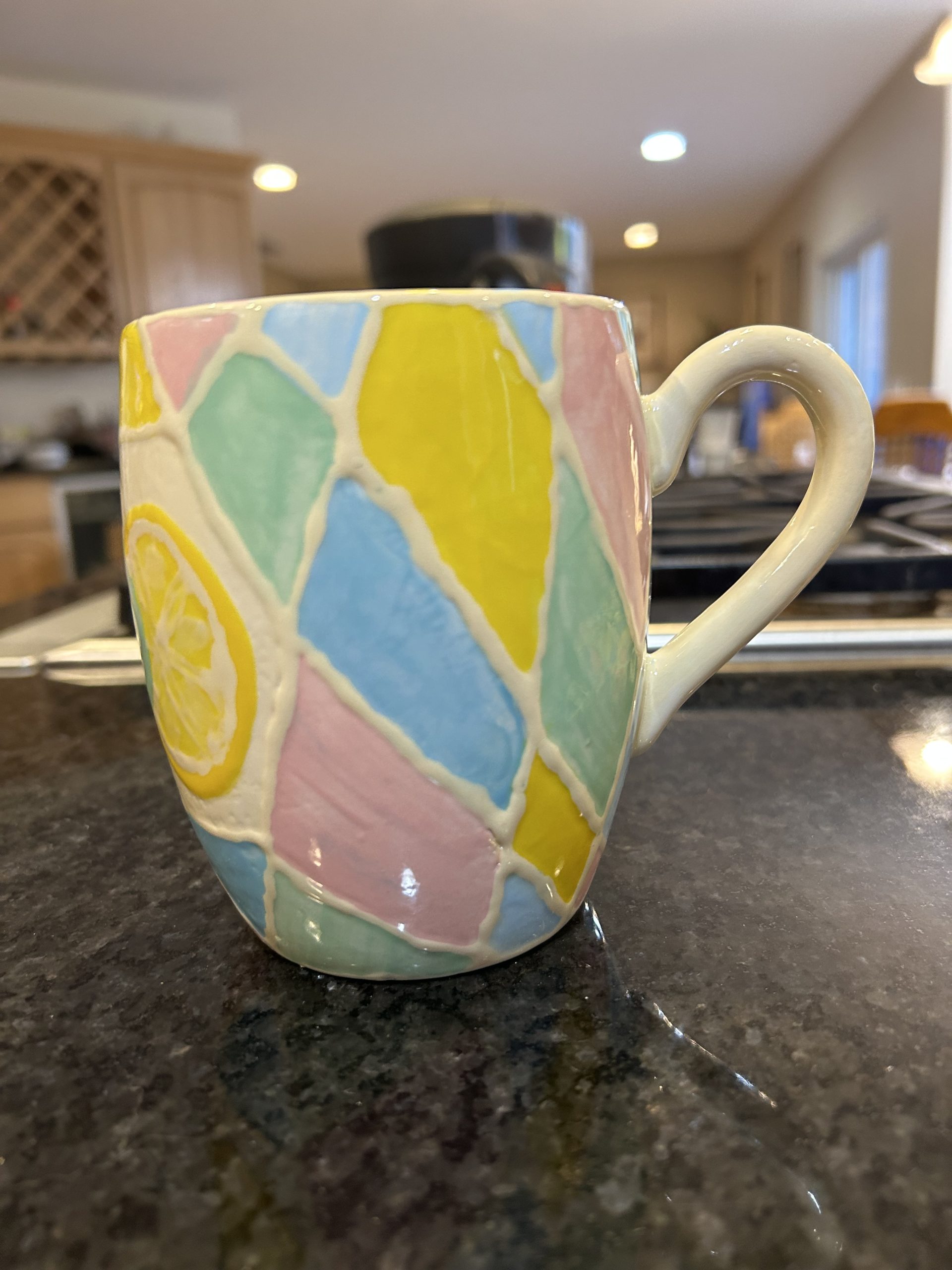 Ceramic mug with geometric pastel shapes and a lemon and lime wedge - side of mug