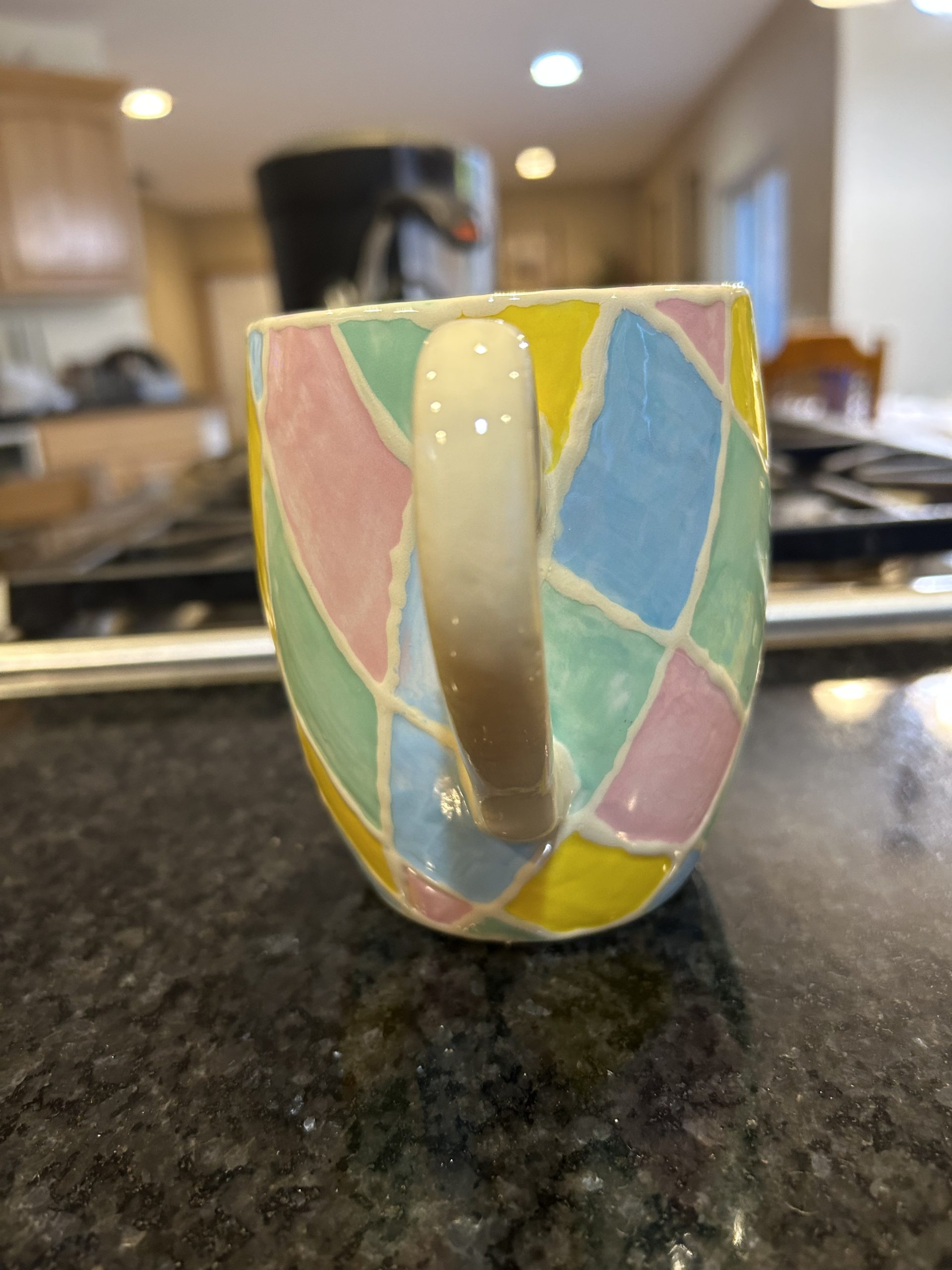 Ceramic mug with geometric pastel shapes and a lemon and lime wedge - rear of mug