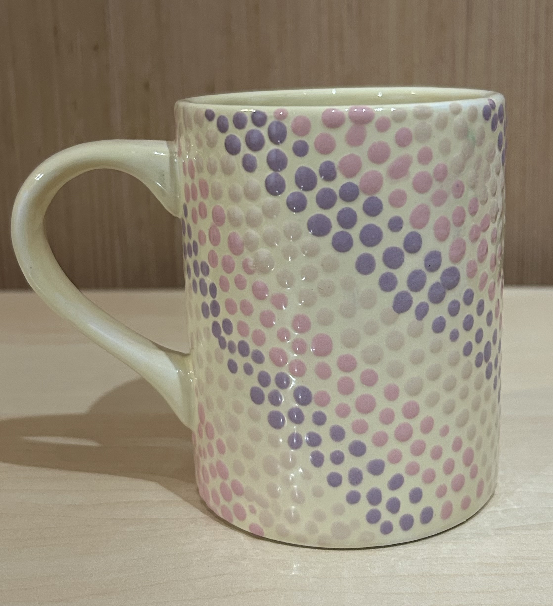 Ceramic mug with purple, pink, and cream dots - side view