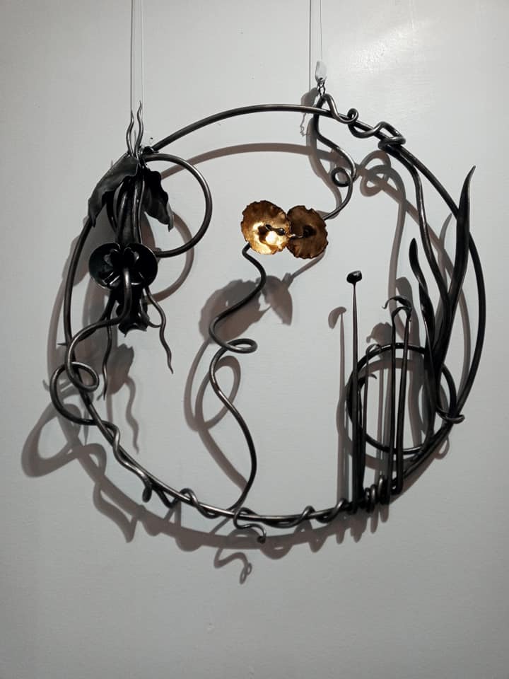 Metalwork art with leaves and vines in a circle