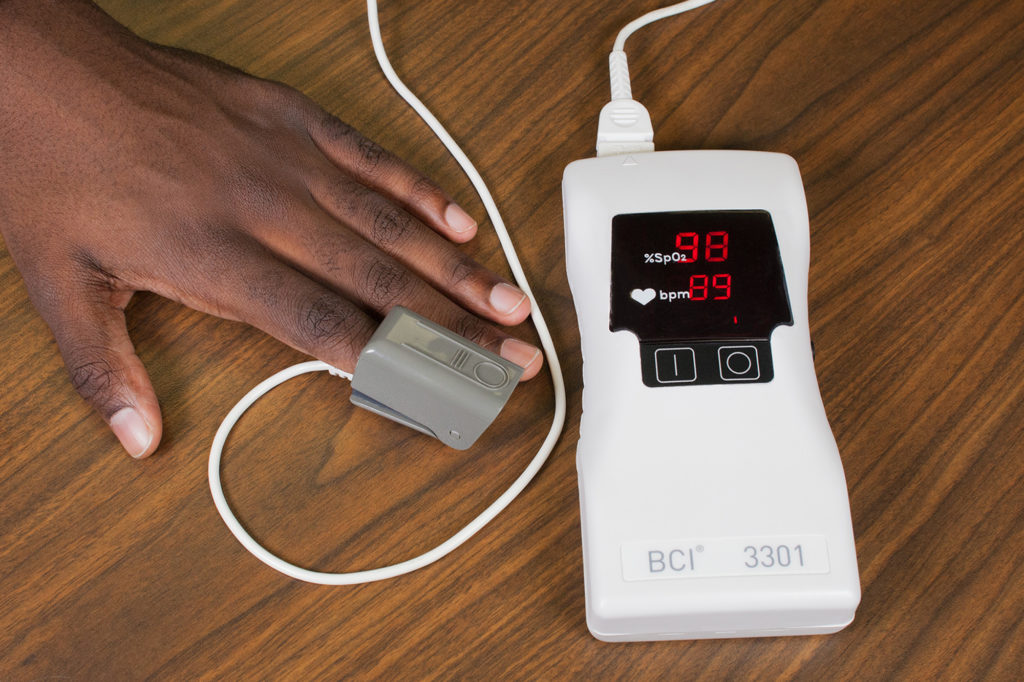 Image showing pulse oximeter in use on simulated patient's index finger